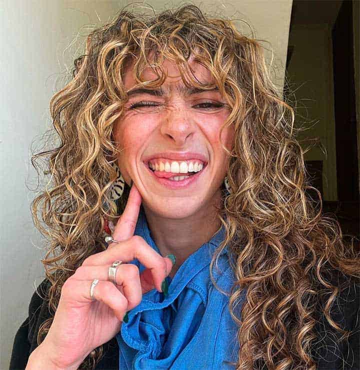 woman smiling and being silly, with curly hair