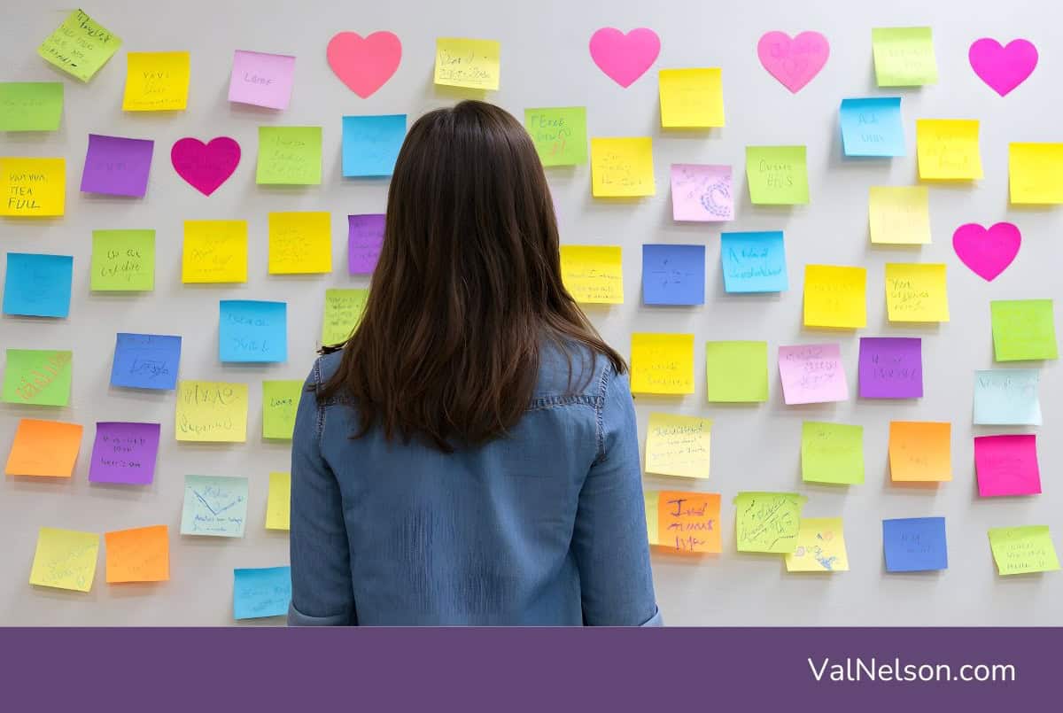 Woman staring at a wall full of sticky notes, trying to be intentional about a next career move.