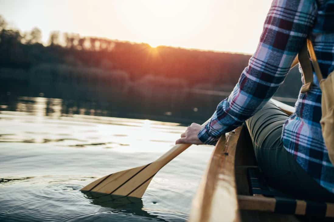 paddling on smooth water at sunset