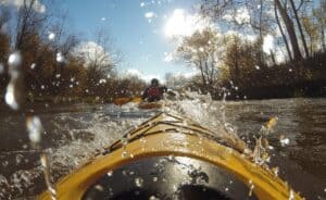 A business pivot can feel like trying to switch boats while paddling on a river. It's rocky to start and hard to switch. Image of paddling on rough river.